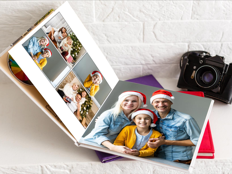 Open premium lay-flat photo book with vintage camera